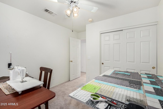 office space featuring light carpet, ceiling fan, and visible vents