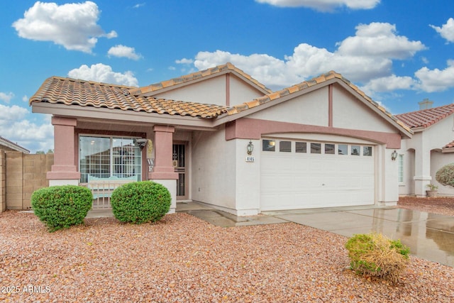 view of front of property with concrete driveway, a tile roof, an attached garage, and stucco siding