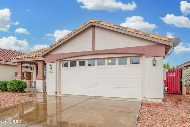 view of front of property featuring a garage, concrete driveway, and stucco siding