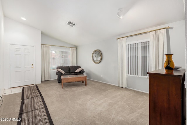 sitting room with lofted ceiling, baseboards, visible vents, and light colored carpet