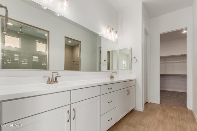 bathroom featuring hardwood / wood-style flooring, vanity, and walk in shower