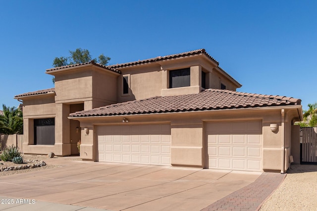 mediterranean / spanish-style house featuring a garage, concrete driveway, and stucco siding