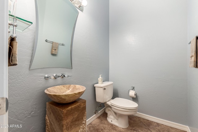 bathroom featuring tile patterned flooring, a sink, toilet, and baseboards