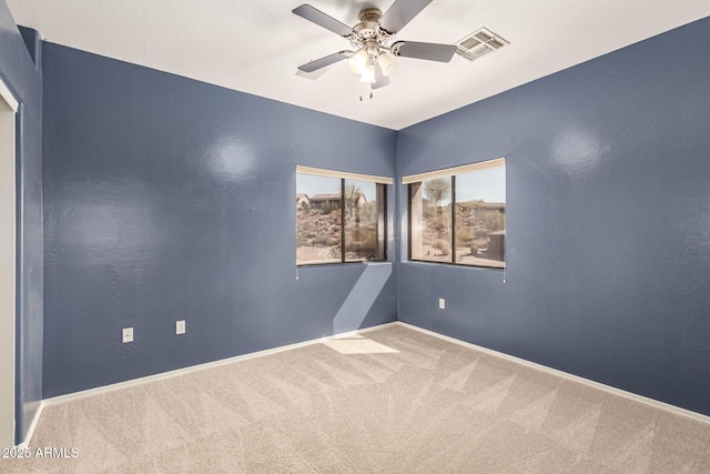 spare room with a ceiling fan, baseboards, visible vents, and carpet flooring