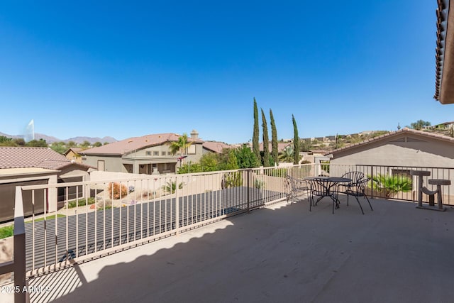 view of patio featuring a mountain view, outdoor dining area, a residential view, and a balcony