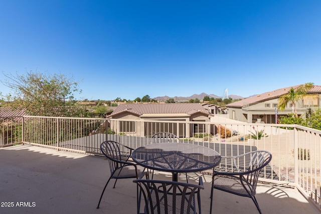 view of patio / terrace with outdoor dining area, a mountain view, and fence