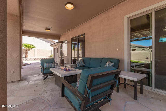 view of patio with an outdoor living space with a fire pit and fence