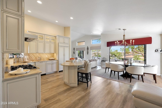 kitchen with pendant lighting, a center island, paneled fridge, and light wood-type flooring