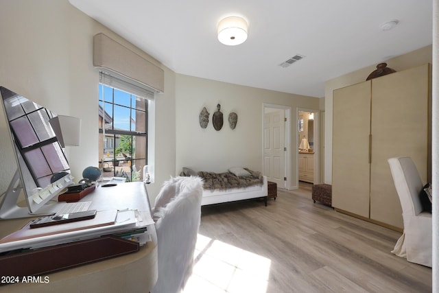 bedroom featuring light hardwood / wood-style floors and connected bathroom