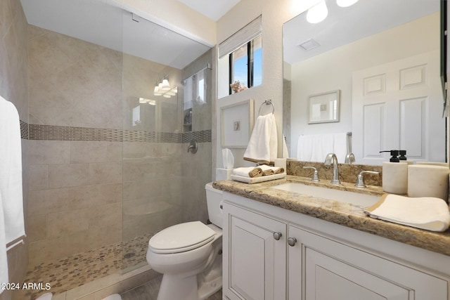 bathroom featuring vanity, toilet, and tiled shower