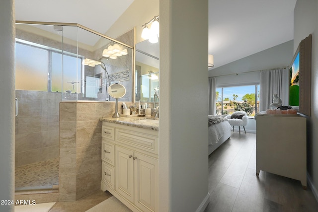 bathroom featuring tile walls, vanity, an enclosed shower, and vaulted ceiling