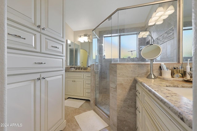 bathroom featuring tile patterned floors, vanity, walk in shower, and tile walls