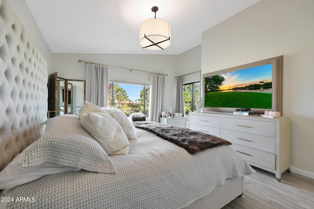 bedroom featuring lofted ceiling and light hardwood / wood-style flooring