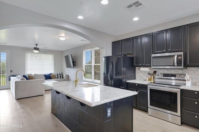 3687 E Leslie Dr, Gilbert, AZ 85296 - kitchen featuring appliances with stainless steel finishes, a sink, light wood-type flooring, tasteful backsplash, and light stone counters