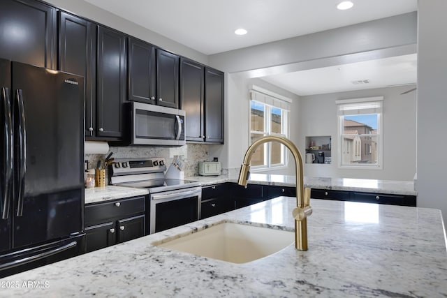 3687 E Leslie Dr, Gilbert, AZ 85296 - kitchen with appliances with stainless steel finishes, dark cabinets, a sink, light stone countertops, and recessed lighting