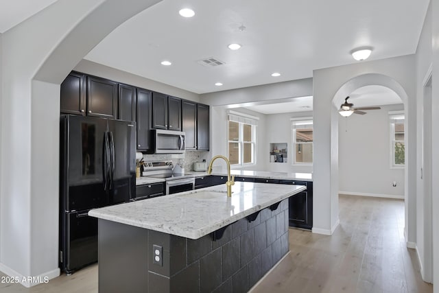3687 E Leslie Dr, Gilbert, AZ 85296 - kitchen with appliances with stainless steel finishes, a sink, ceiling fan, a center island with sink, and light stone counters