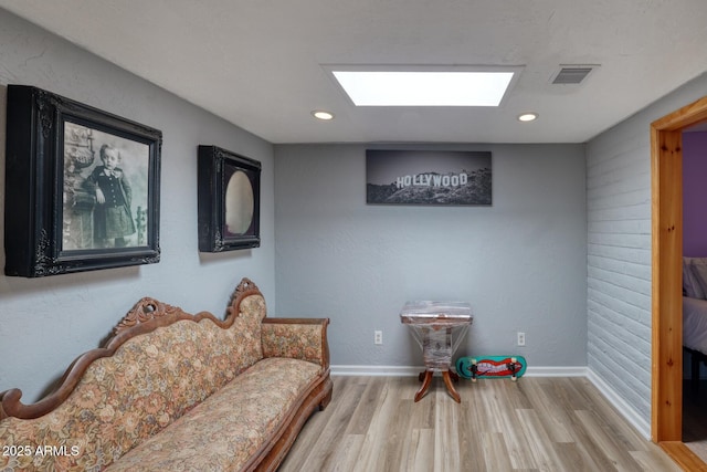 living area with light wood-style floors, visible vents, baseboards, and recessed lighting