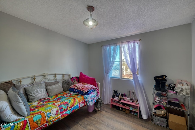 bedroom featuring a textured ceiling and wood finished floors