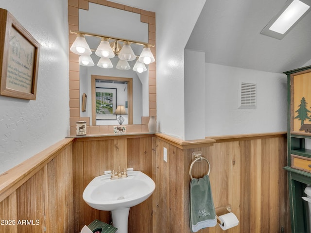 4567 N Juniper Ln, Pine, AZ 85544 - bathroom featuring wainscoting, wood walls, a textured wall, and a sink