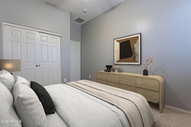 bedroom featuring vaulted ceiling, light carpet, and a closet