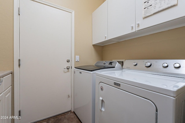 clothes washing area featuring cabinets and washer and clothes dryer