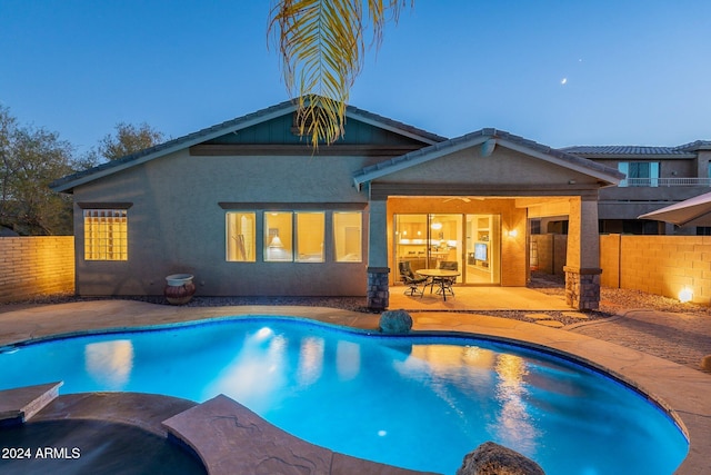 pool at dusk featuring a patio area