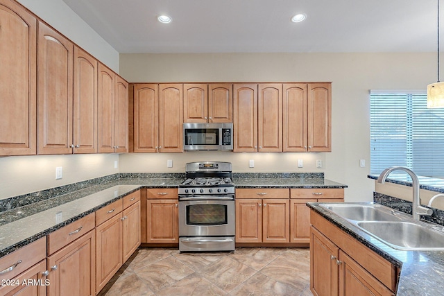 kitchen featuring pendant lighting, dark stone countertops, sink, and appliances with stainless steel finishes