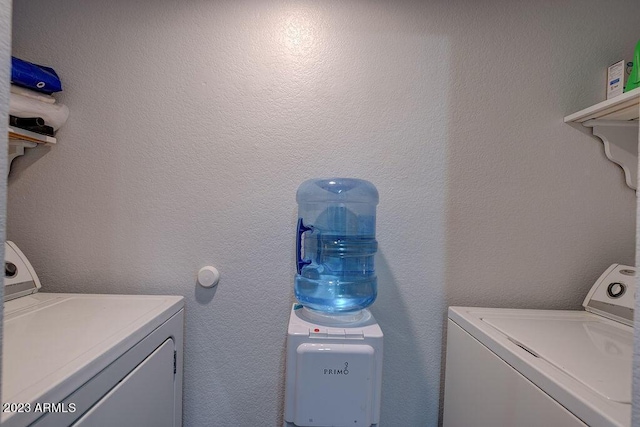 clothes washing area featuring separate washer and dryer and laundry area