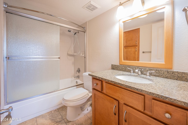 bathroom with vanity, washtub / shower combination, a textured wall, toilet, and visible vents