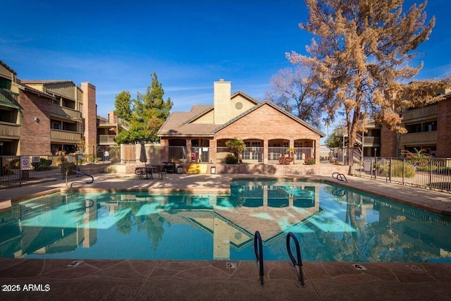 pool featuring a patio area and fence