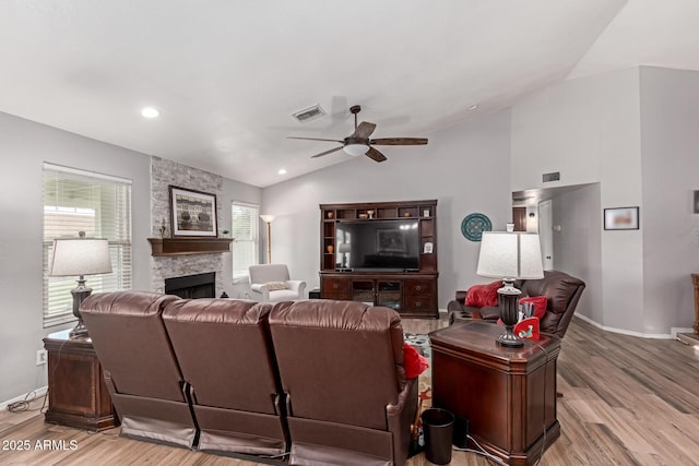 19 W Wickieup Ln, Phoenix, AZ 85027 - living room with vaulted ceiling, a ceiling fan, wood finished floors, a stone fireplace, and baseboards