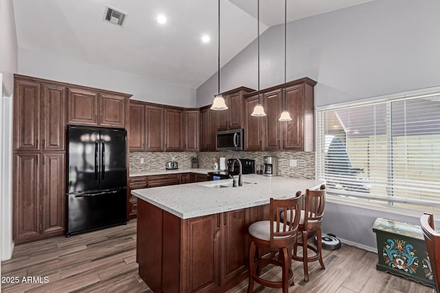 19 W Wickieup Ln, Phoenix, AZ 85027 - kitchen featuring freestanding refrigerator, stainless steel microwave, a peninsula, a sink, and light wood-style floors