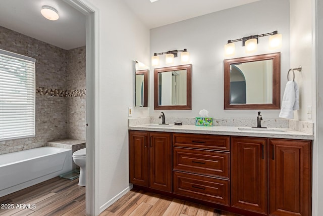 19 W Wickieup Ln, Phoenix, AZ 85027 - bathroom with toilet, double vanity, wood finished floors, and a garden tub