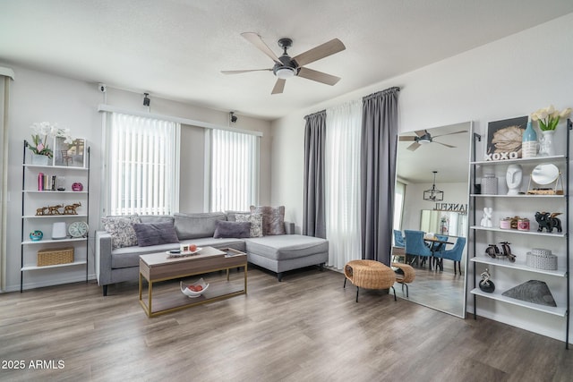 living area featuring a textured ceiling, wood finished floors, and a ceiling fan