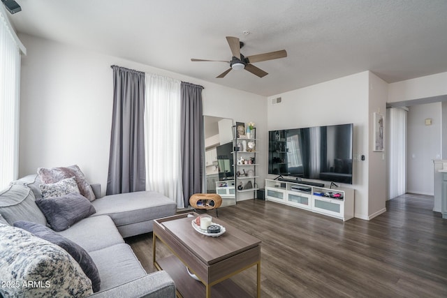 living room with a ceiling fan, baseboards, visible vents, and wood finished floors