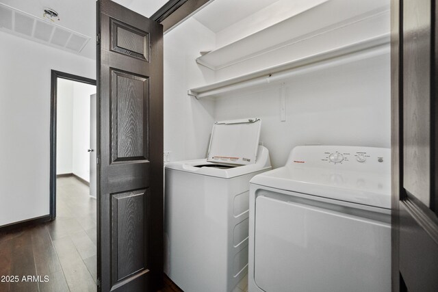 laundry room featuring washing machine and clothes dryer and dark wood finished floors