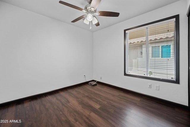 empty room with dark wood-type flooring, baseboards, and ceiling fan