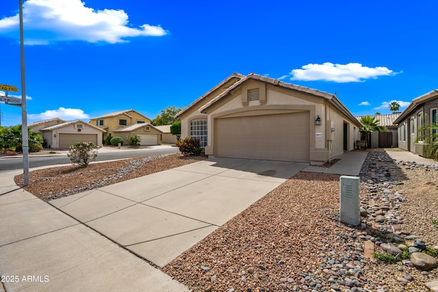 view of front of property featuring driveway, stucco siding, a garage, and fence