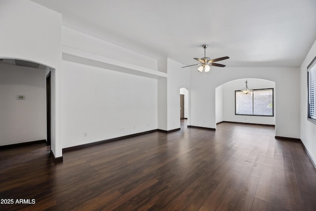 unfurnished living room featuring arched walkways, ceiling fan, dark wood-type flooring, and baseboards