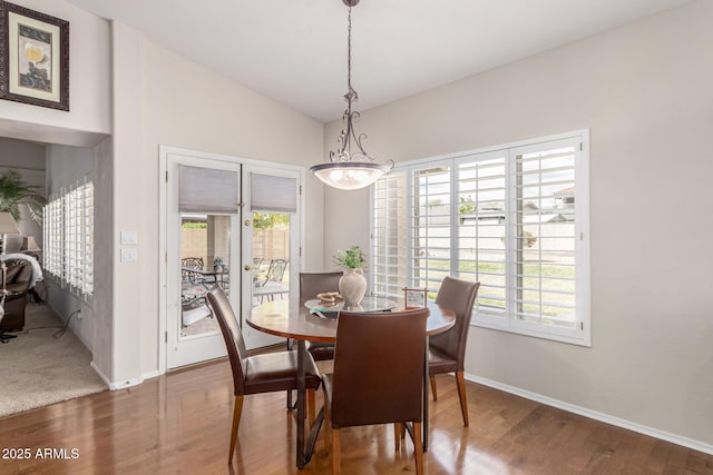 dining space with lofted ceiling, plenty of natural light, baseboards, and wood finished floors