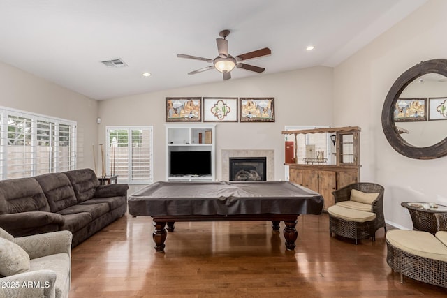 living area with visible vents, a glass covered fireplace, lofted ceiling, wood finished floors, and pool table