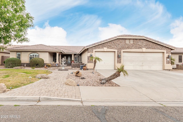 single story home with a tile roof, stucco siding, a garage, stone siding, and driveway