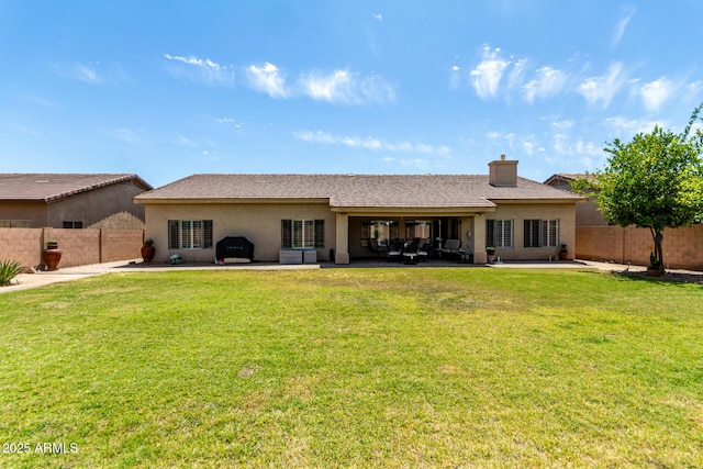 rear view of house featuring a yard, a fenced backyard, a patio area, and stucco siding