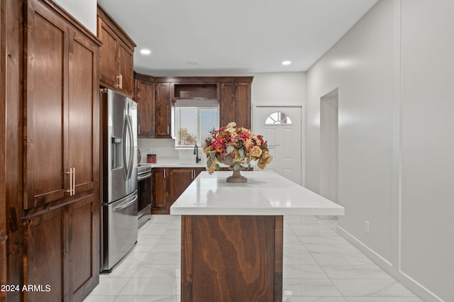 kitchen featuring stainless steel appliances, sink, and a kitchen island