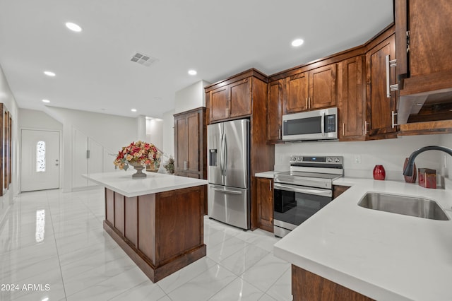 kitchen with a center island, stainless steel appliances, and sink