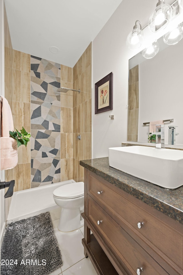 bathroom with vanity, toilet, tiled shower, and tile patterned flooring