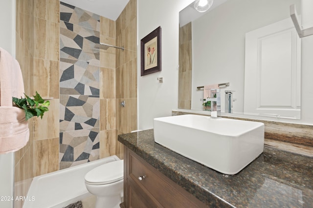 full bathroom featuring toilet, tiled shower / bath combo, vanity, and tile walls