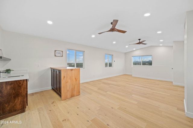 kitchen with light hardwood / wood-style floors, lofted ceiling, sink, and kitchen peninsula