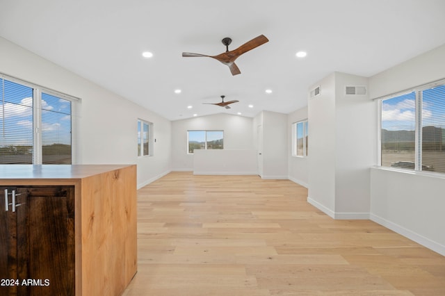 unfurnished living room featuring light hardwood / wood-style flooring, lofted ceiling, and ceiling fan