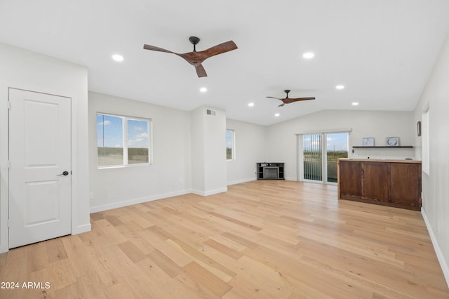 unfurnished living room featuring ceiling fan, light wood-type flooring, and vaulted ceiling